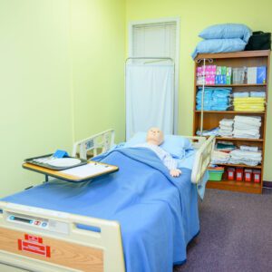 Dummy laying on a hospital bed with a blue blanked covering it