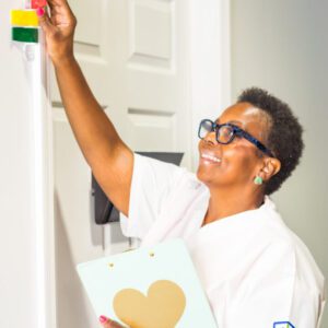 Woman reaching up to place a sticky note on a wall or board.